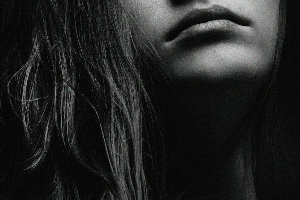 black and white image of a woman's mouth and long hair.